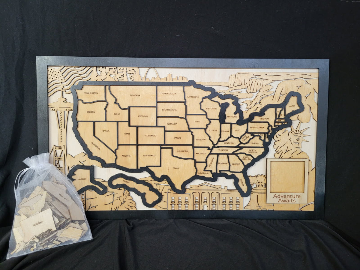 A framed wooden US states map puzzle board with engraved state outlines and a small bag of puzzle pieces on a black fabric background.